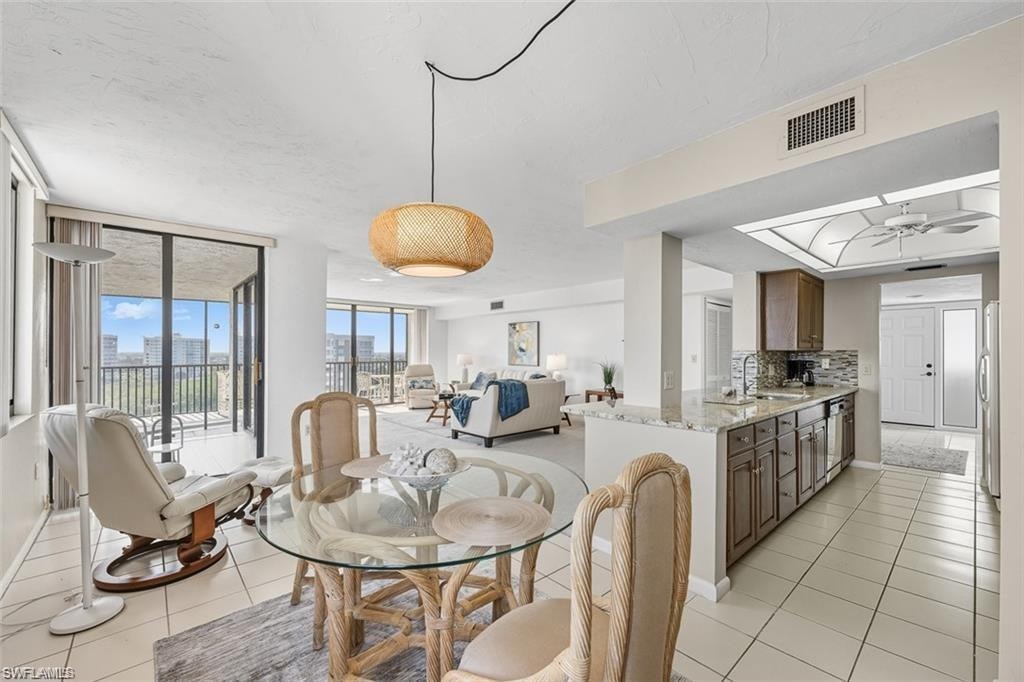 Dining room with expansive windows and light tile patterned floors