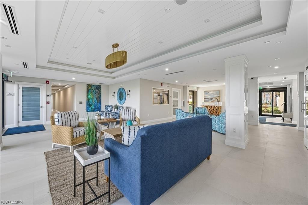 Lobby Living area featuring a raised ceiling, ornate columns, and recessed lighting