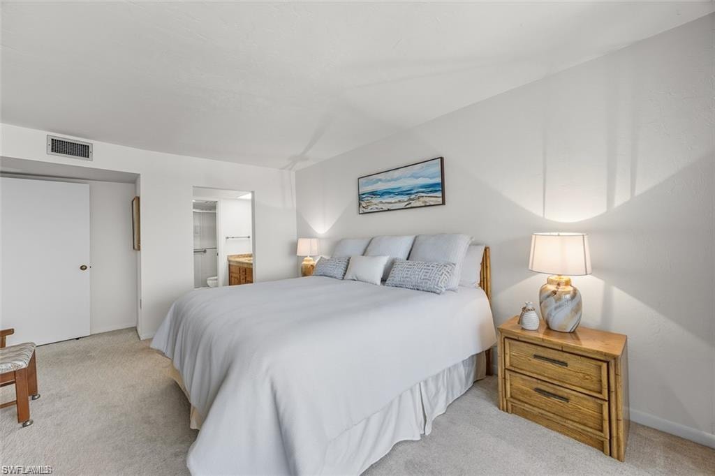 Bedroom featuring ensuite bath and carpet