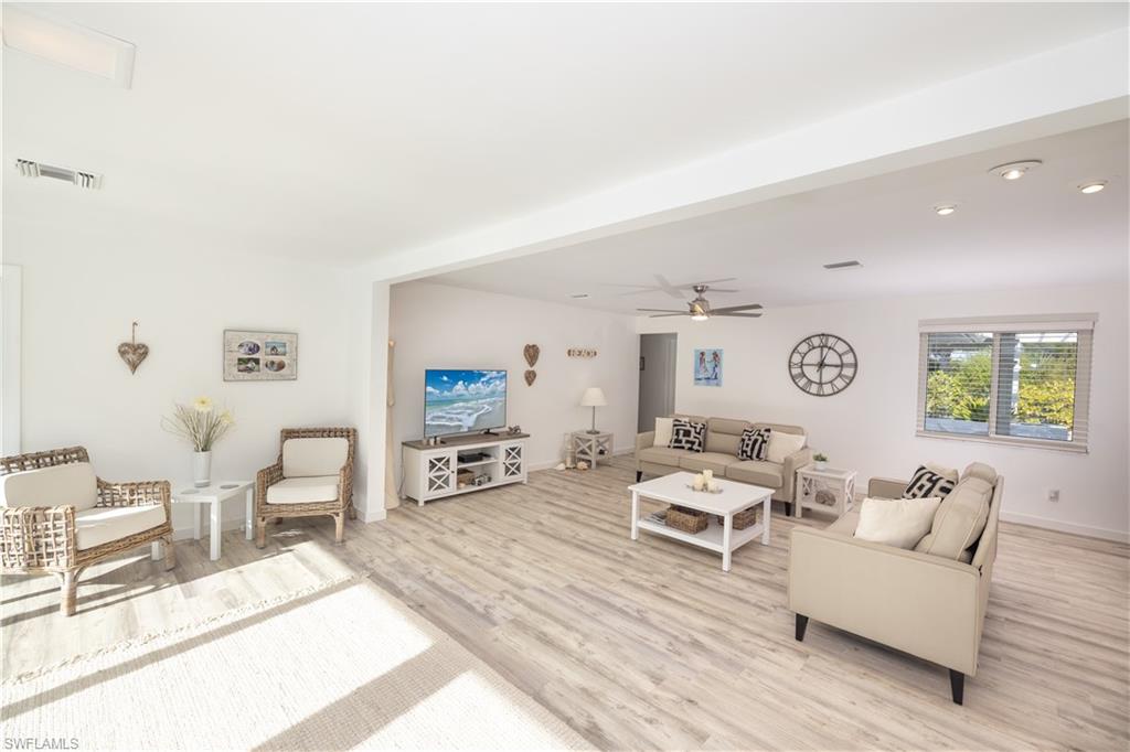 Living room with ceiling fan, recessed lighting, and light wood-style flooring