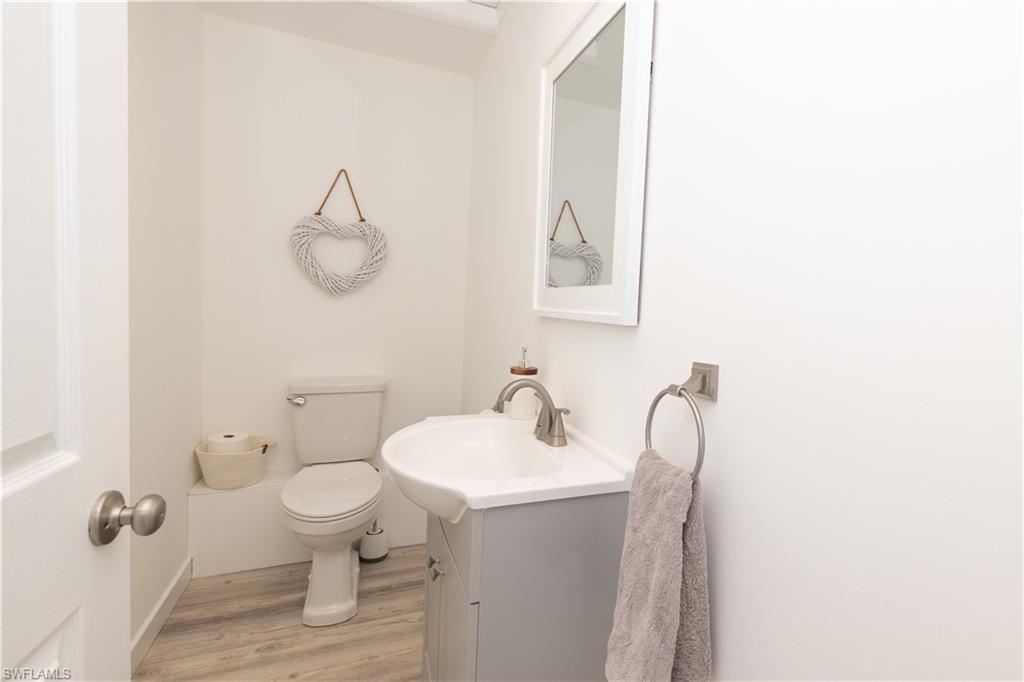 Half bathroom featuring vanity and light wood-type flooring