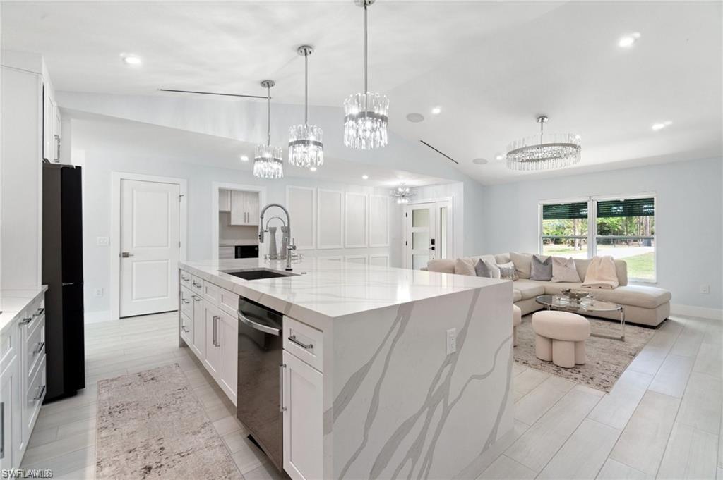 Large entertaining island with imported Pompei quartz, chandeliers, large walk-in pantry with custom cabinets and shelving, Wolf induction cooktop.