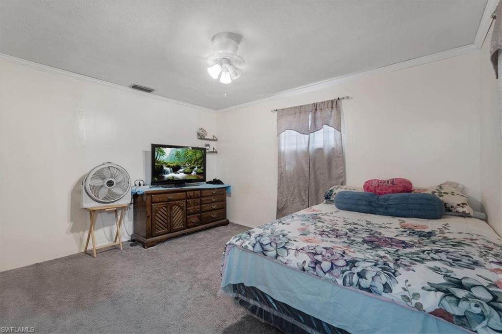 Bedroom featuring ornamental molding and carpet flooring
