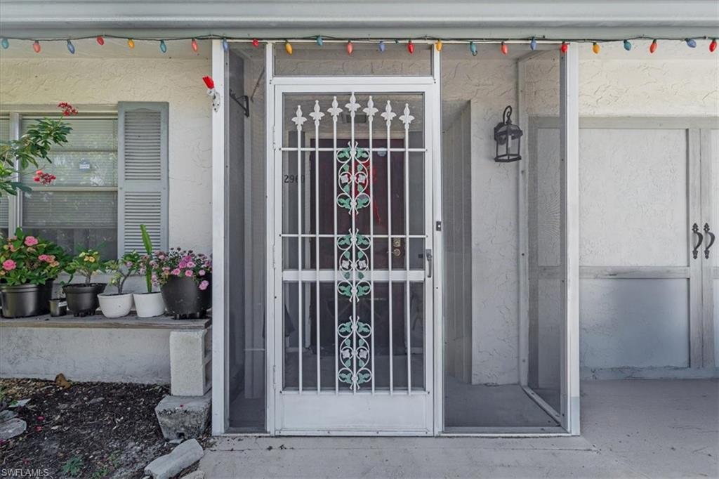 Property entrance featuring stucco siding and a porch