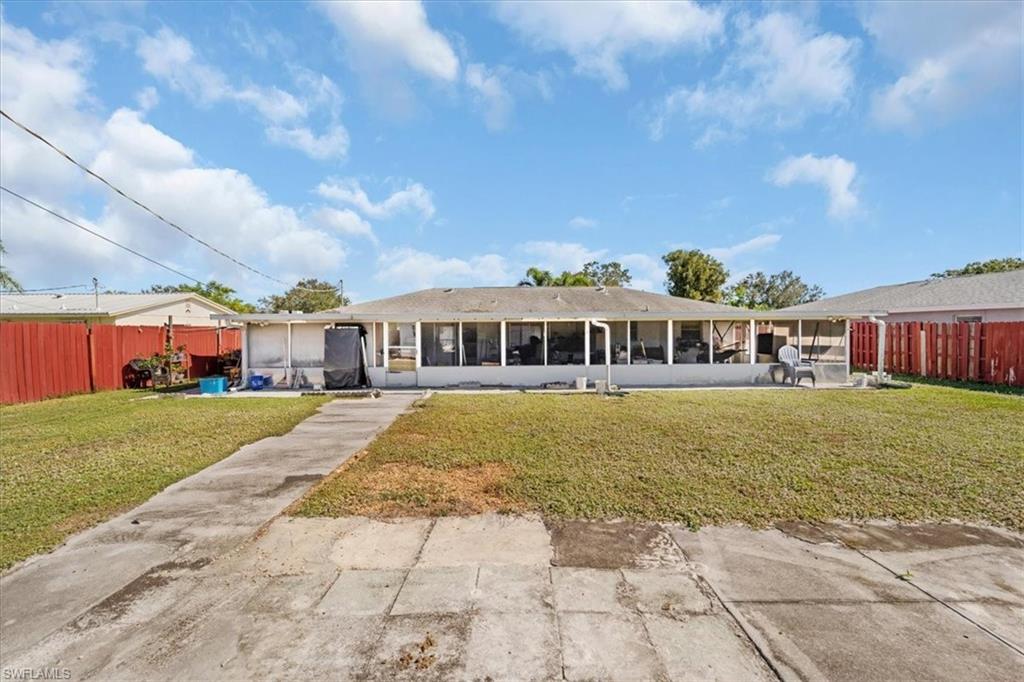 Back of property featuring a fenced backyard, a sunroom, and a patio