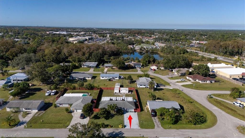 Aerial view of property and surrounding area featuring nearby suburban area and a large body of water