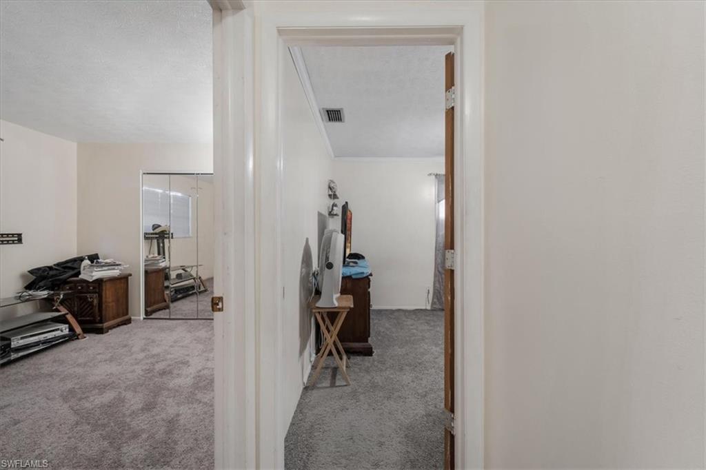 Hall featuring light colored carpet