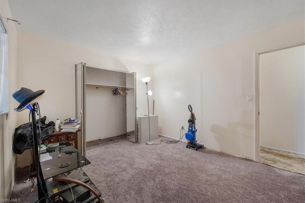 Carpeted bedroom featuring a closet and a textured ceiling