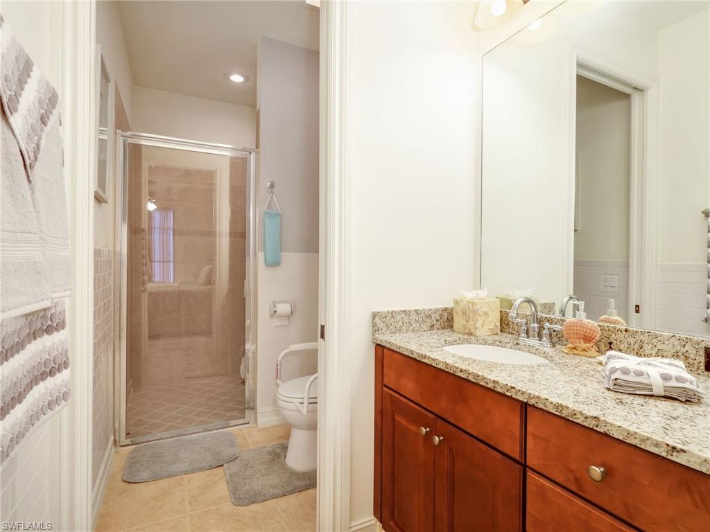 Full bath featuring vanity, a stall shower, light tile patterned floors, and recessed lighting