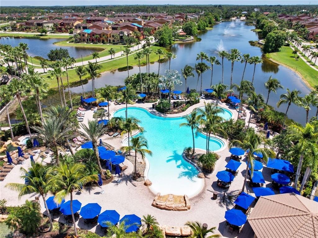 Aerial perspective of suburban area featuring a pool and a nearby body of water
