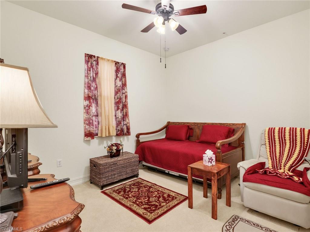Carpeted bedroom with a ceiling fan and baseboards