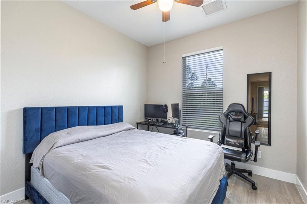 Bedroom with ceiling fan and light wood-type flooring