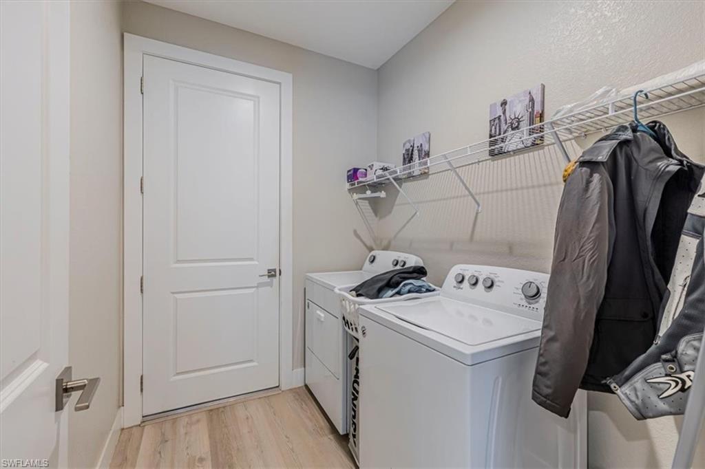 Laundry area with light wood-style flooring and separate washer and dryer