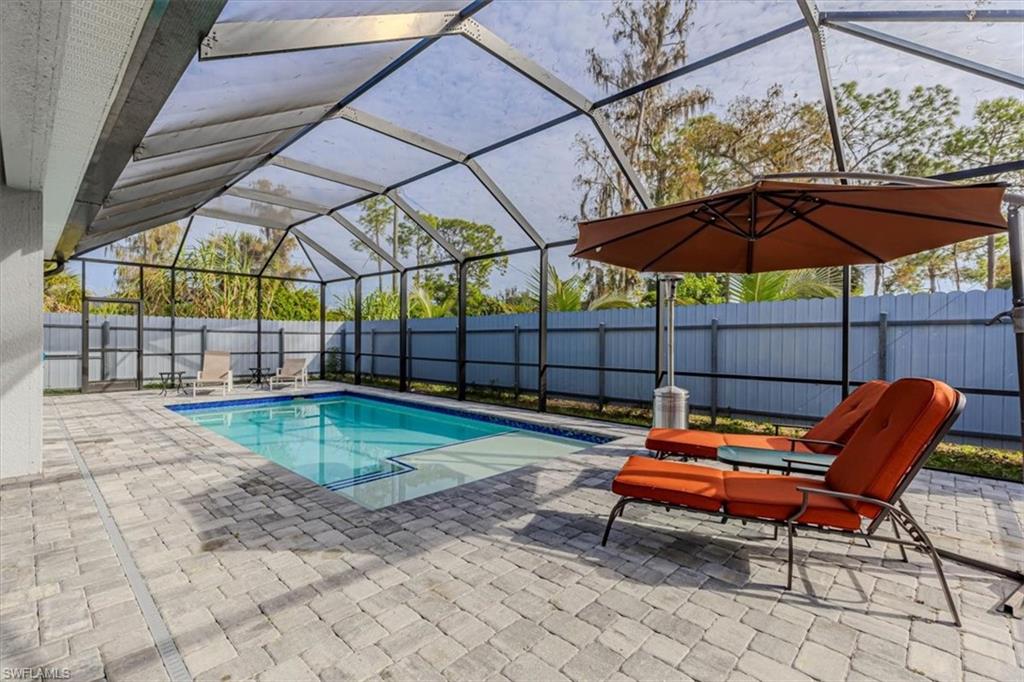 View of swimming pool with a patio area, a sunroom, glass enclosure, and a fenced backyard