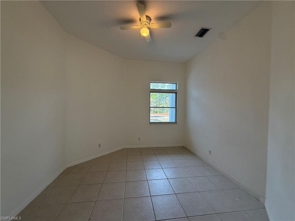 Spare room with light tile patterned floors and a ceiling fan