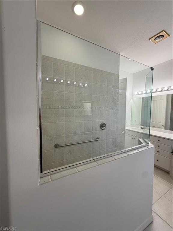 Full bath with a walk in shower, vanity, and light tile patterned flooring