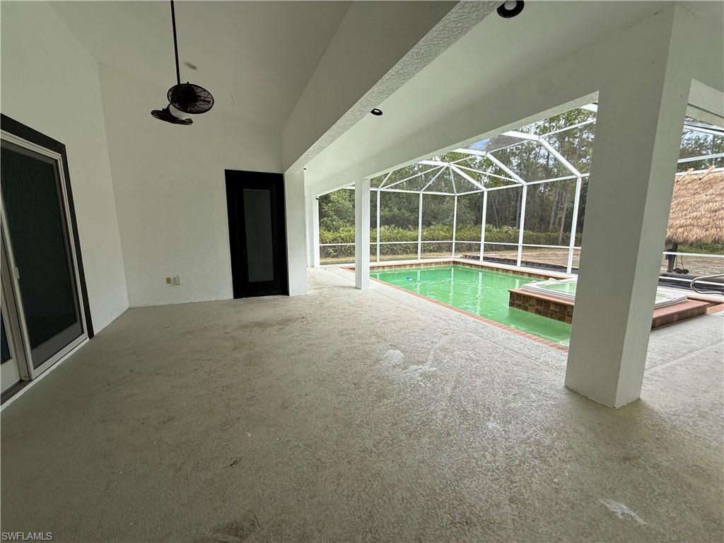 View of swimming pool featuring a sunroom, a patio area, a lanai, and a pool with connected hot tub