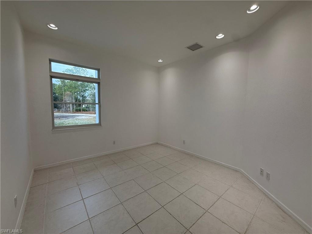 Unfurnished room with light tile patterned floors and recessed lighting