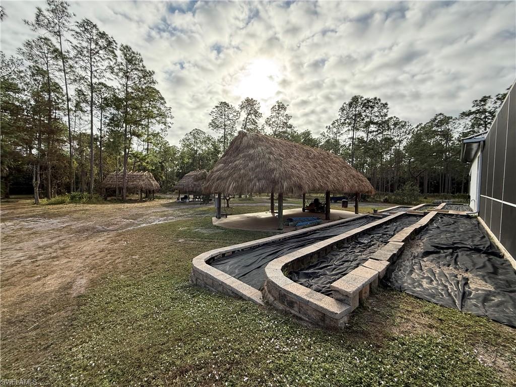 View of property's community with a patio and a lawn