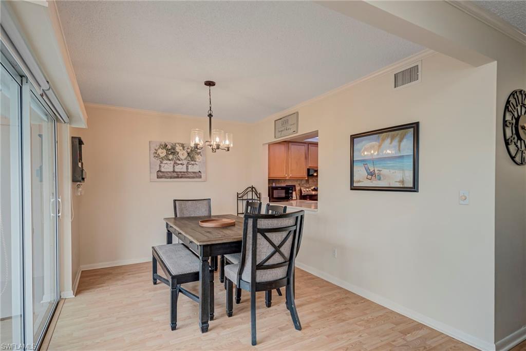 Dining area featuring crown molding, a chandelier, and light wood finished floors