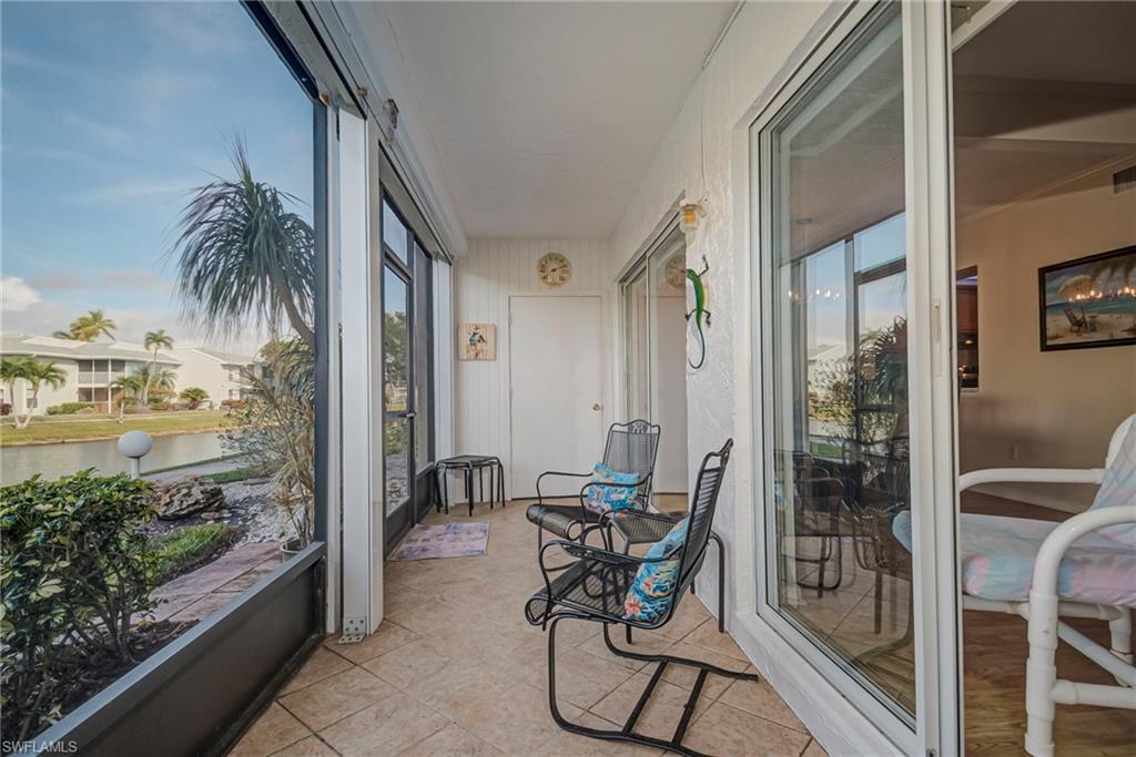 Sunroom / solarium with a water view, healthy amount of natural light, and tile patterned flooring