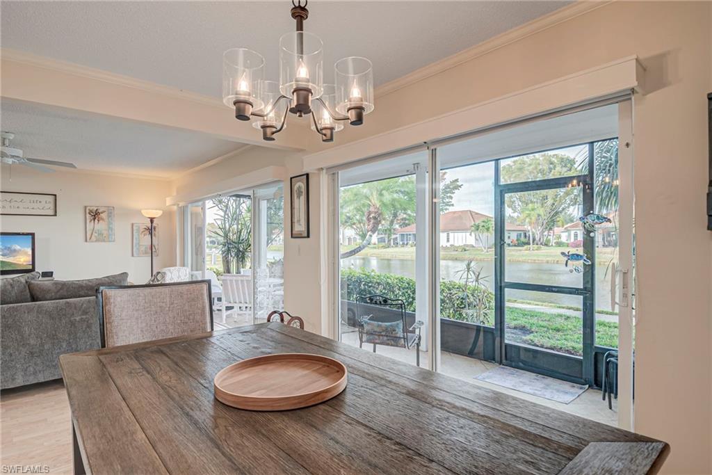 Dining area with ornamental molding, healthy amount of natural light, a water view, ceiling fan, and light wood-type flooring