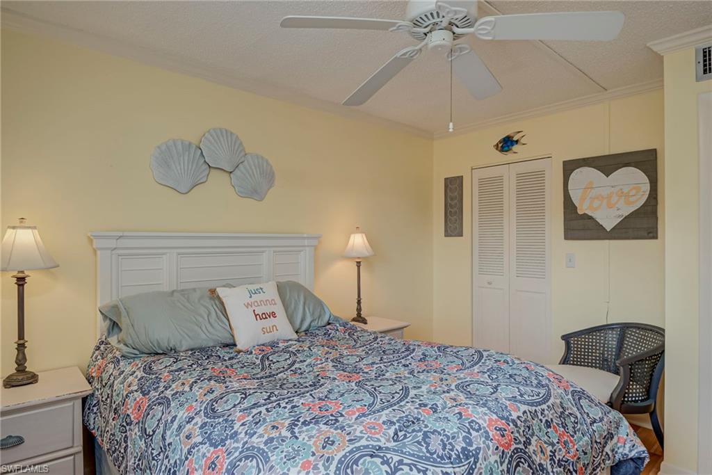 Bedroom featuring ornamental molding, a ceiling fan, a closet, and a textured ceiling