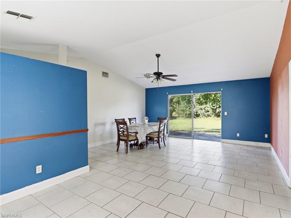 Dining room featuring lofted ceiling, a ceiling fan, and light tile patterned floors