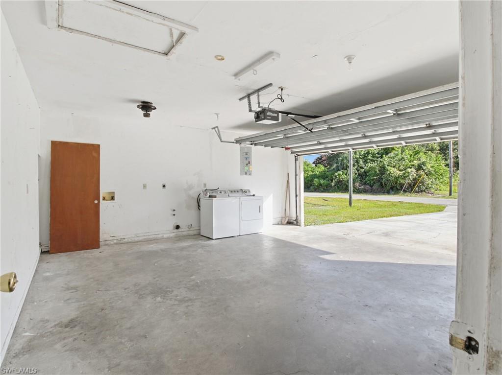 Garage featuring independent washer and dryer and a garage door opener