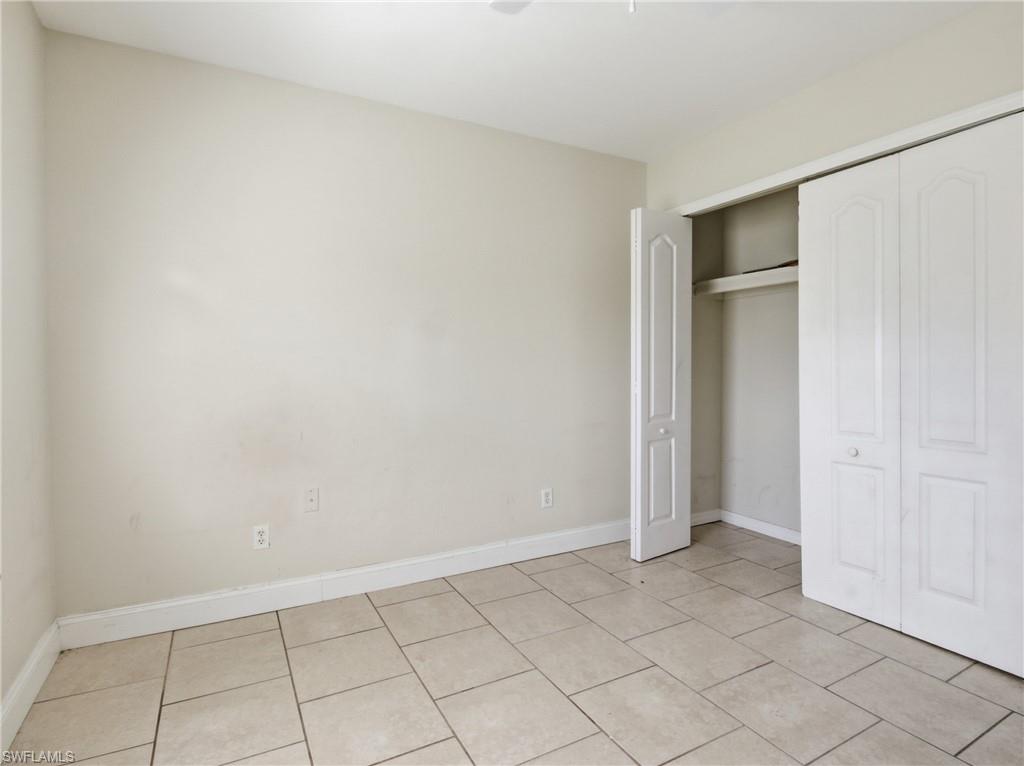 Unfurnished bedroom with a closet and light tile patterned floors