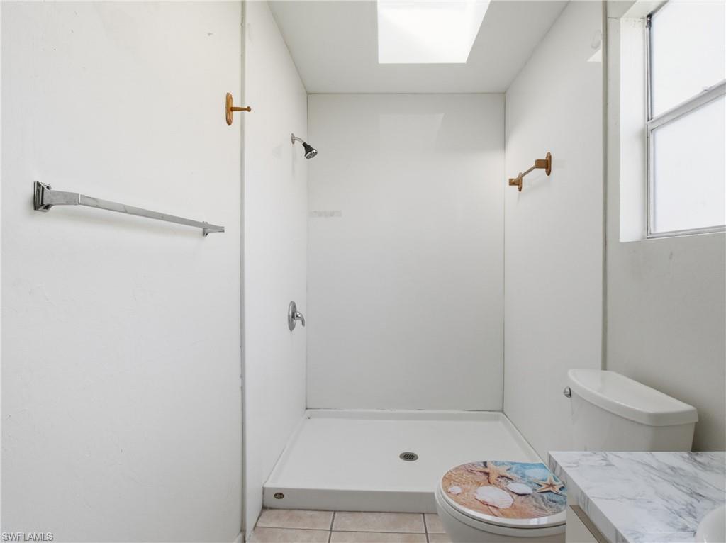 Bathroom featuring vanity, a stall shower, and light tile patterned floors