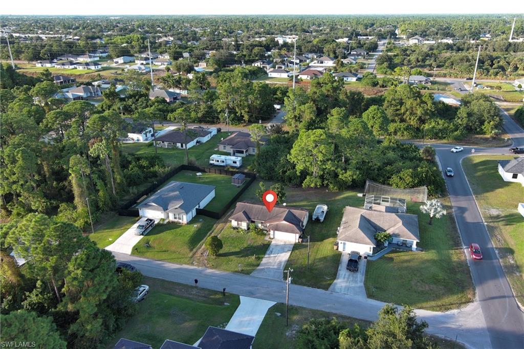 Aerial view of property and surrounding area featuring nearby suburban area