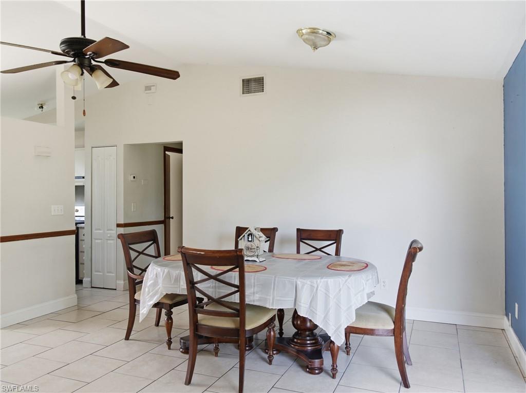 Dining room with lofted ceiling, a ceiling fan, and light tile patterned floors