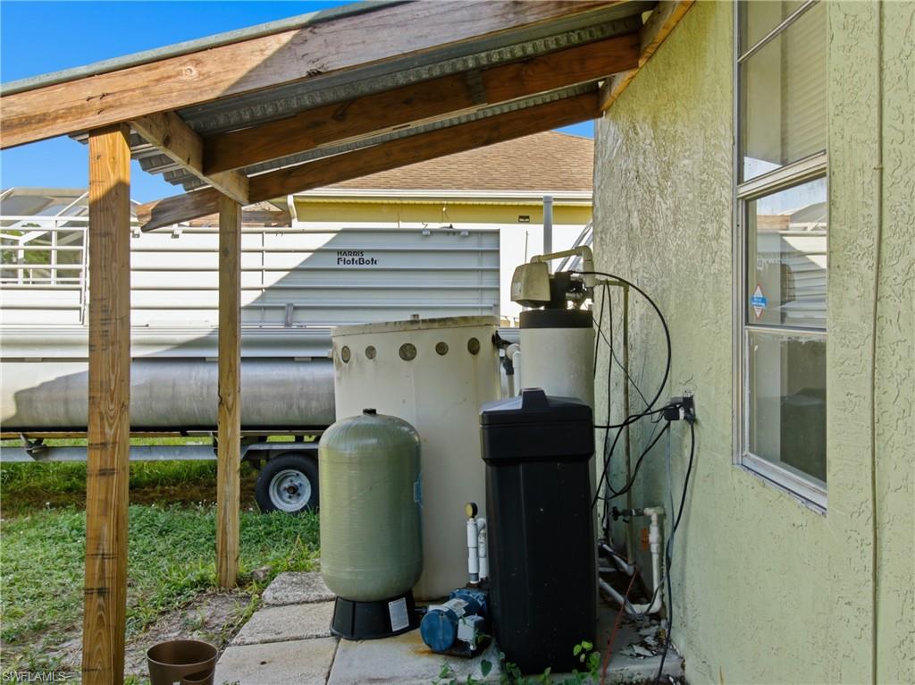 Exterior view of stucco siding and a water softener system