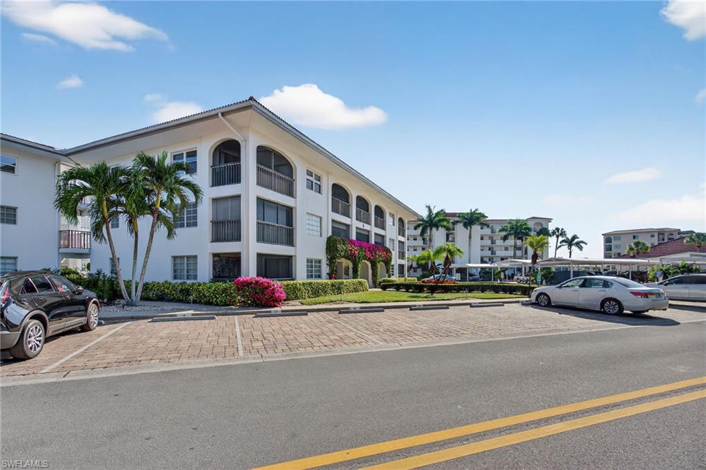 View of apartment building / complex with uncovered parking