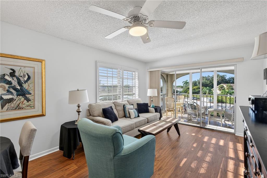 Living area with dark wood-style flooring, a textured ceiling, and a ceiling fan