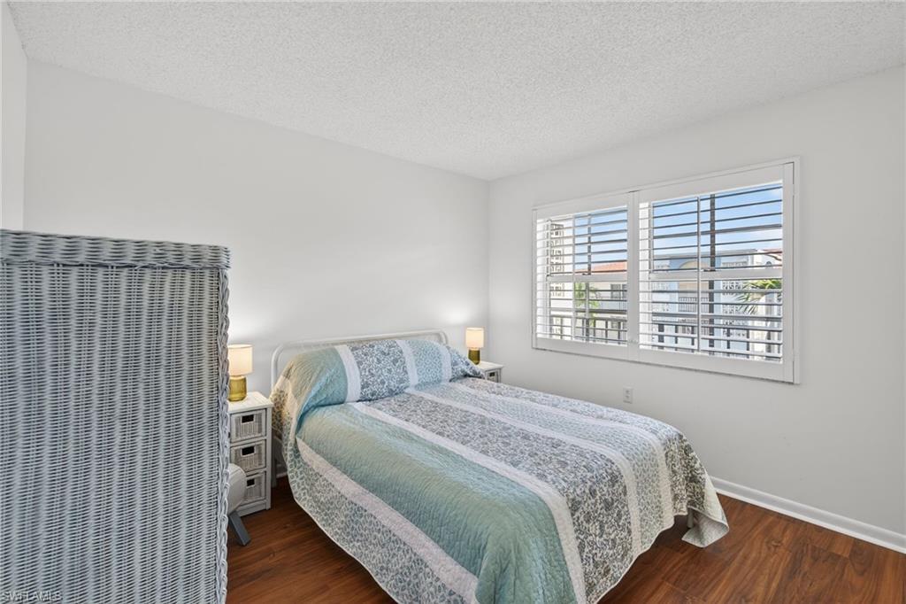 Bedroom featuring a textured ceiling and dark wood-style flooring