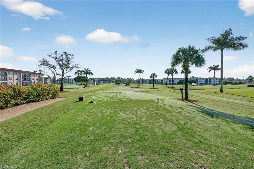 View of home's community featuring a yard and view of golf course