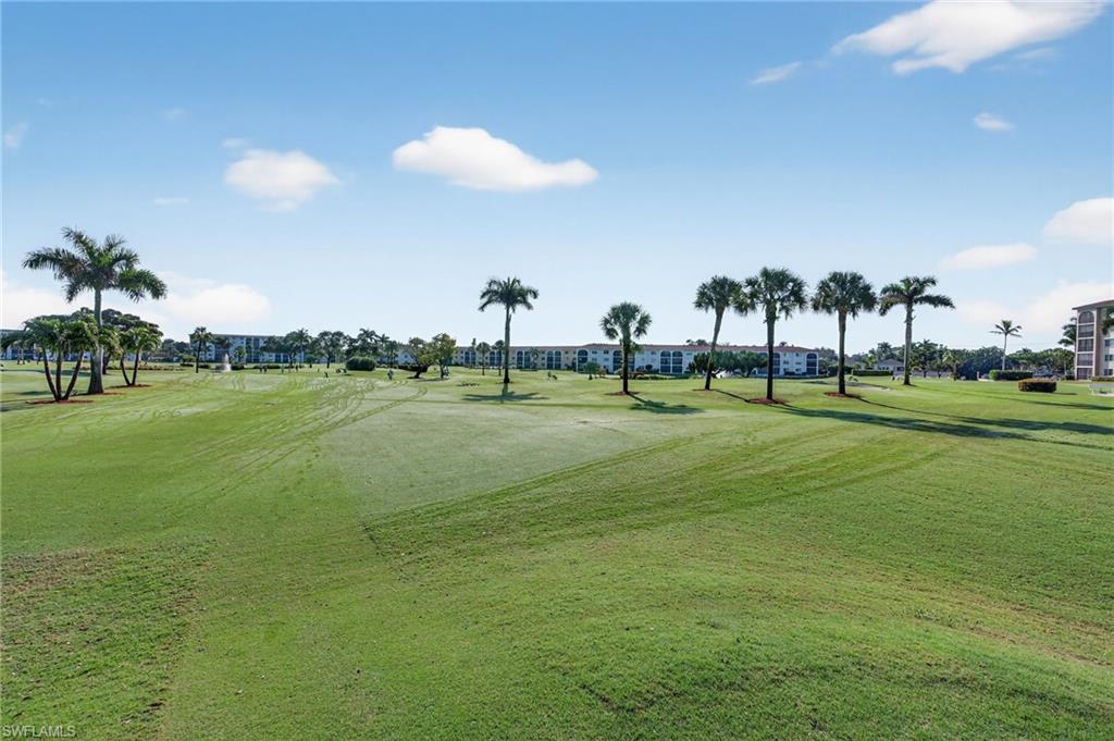 View of home's community with a yard and view of golf course