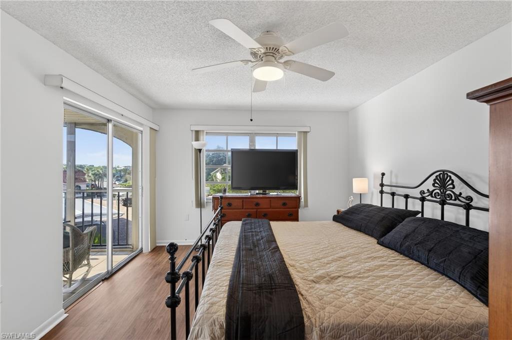 Bedroom featuring wood finished floors, a textured ceiling, access to exterior, and a ceiling fan