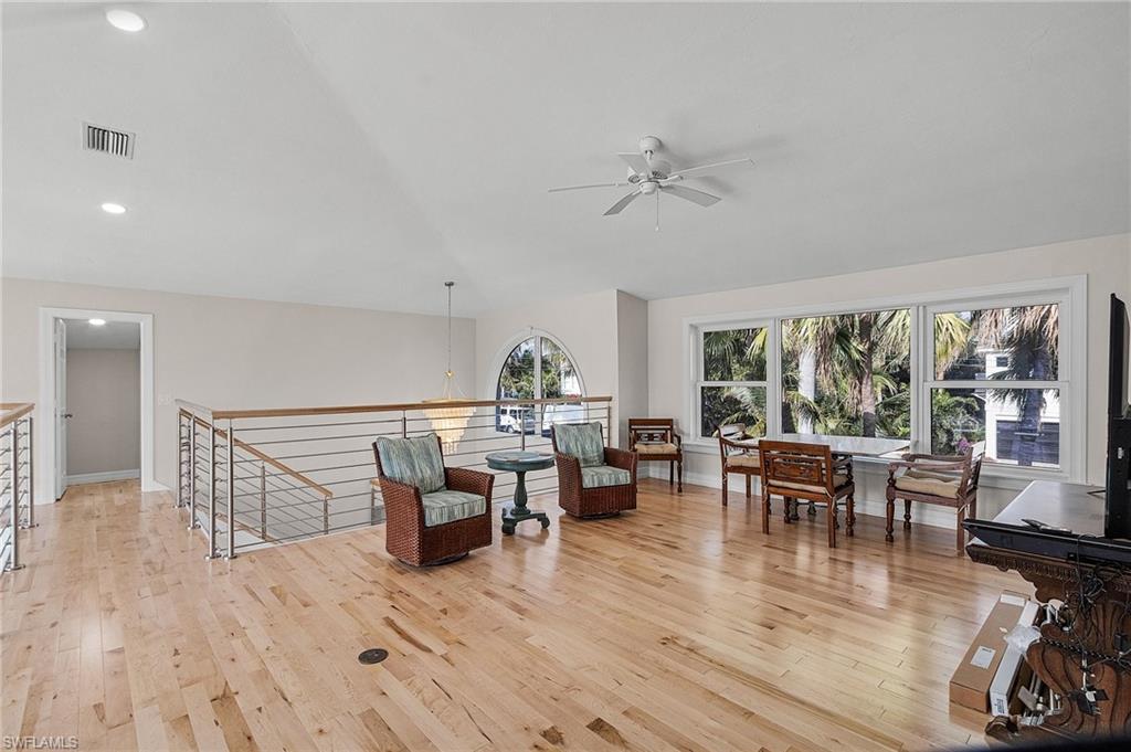 Living area featuring an upstairs landing, light wood-style floors, a ceiling fan, lofted ceiling, and recessed lighting