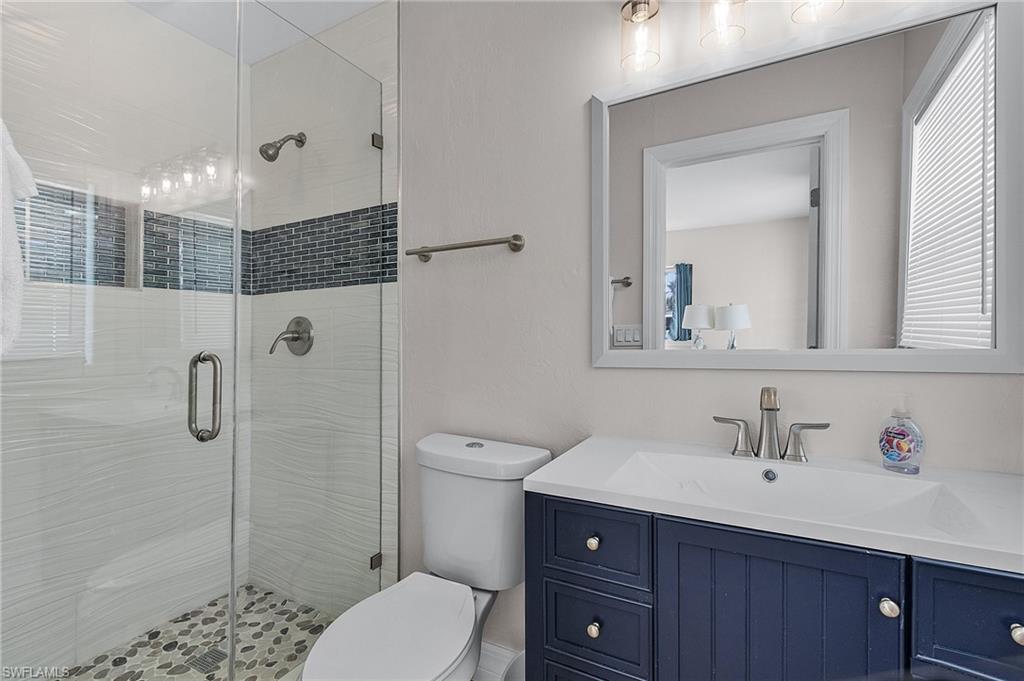 Full bath with a shower stall and vanity