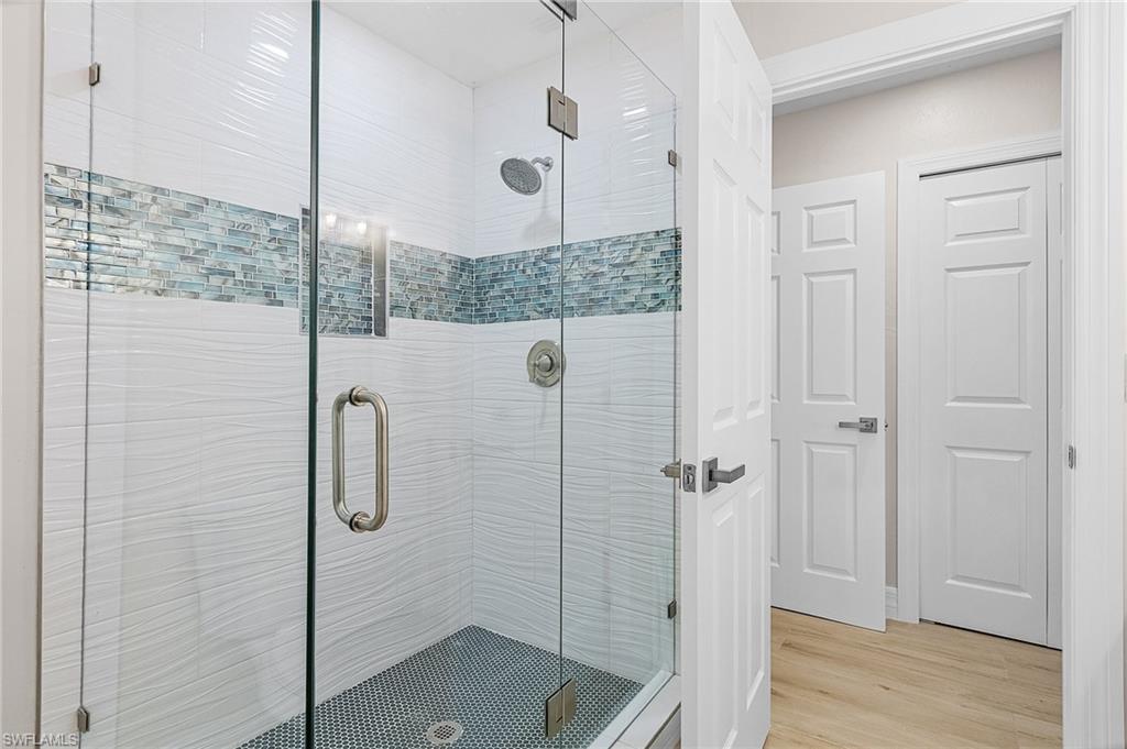 Full bathroom with a stall shower and light wood finished floors