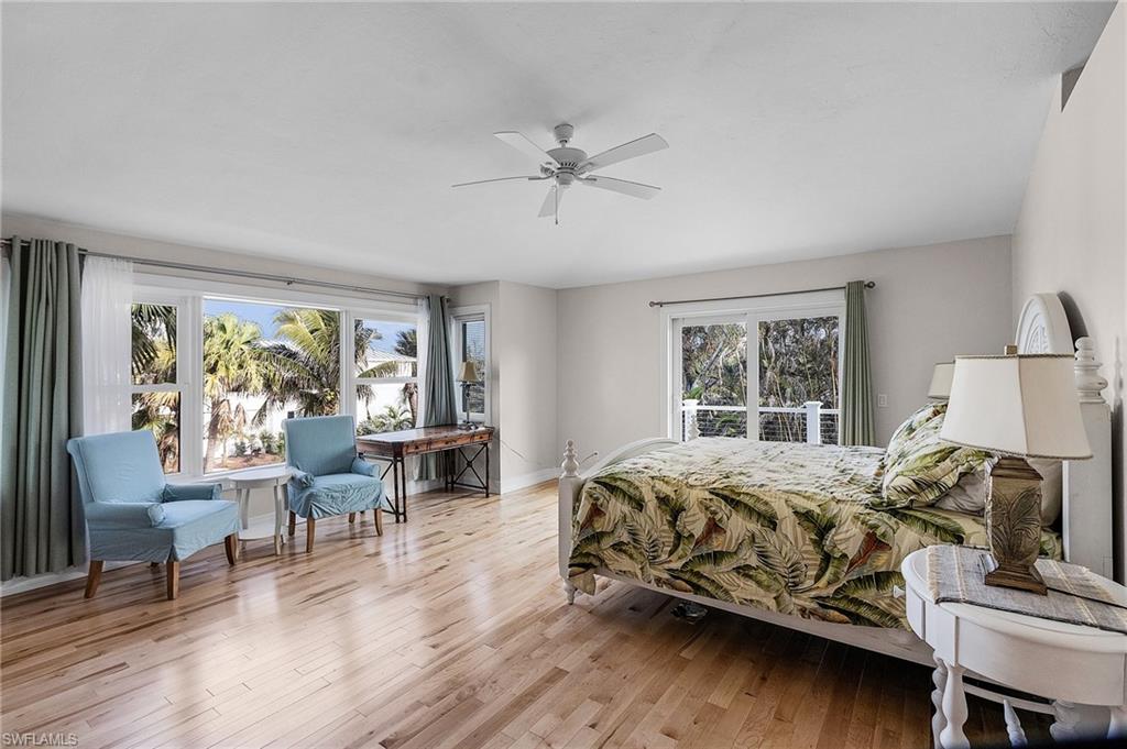 Bedroom with multiple windows, light wood finished floors, and ceiling fan