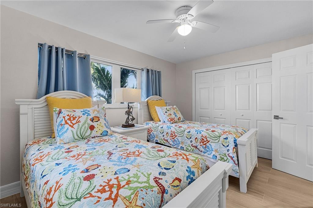 Bedroom featuring wood tiled floors, a closet, and ceiling fan