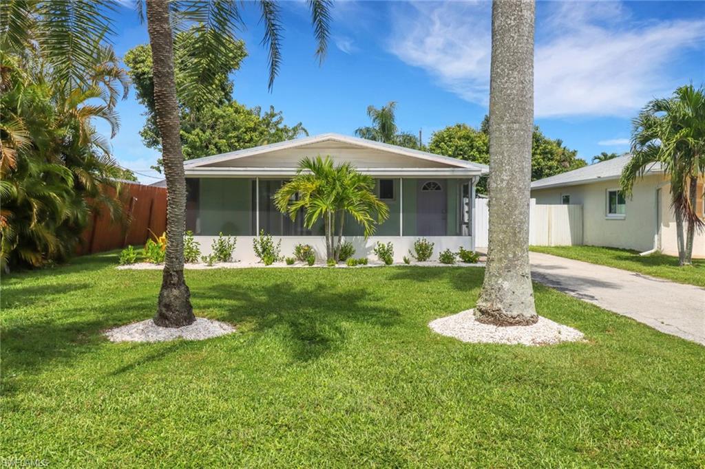 Single story home featuring a sunroom and a front lawn