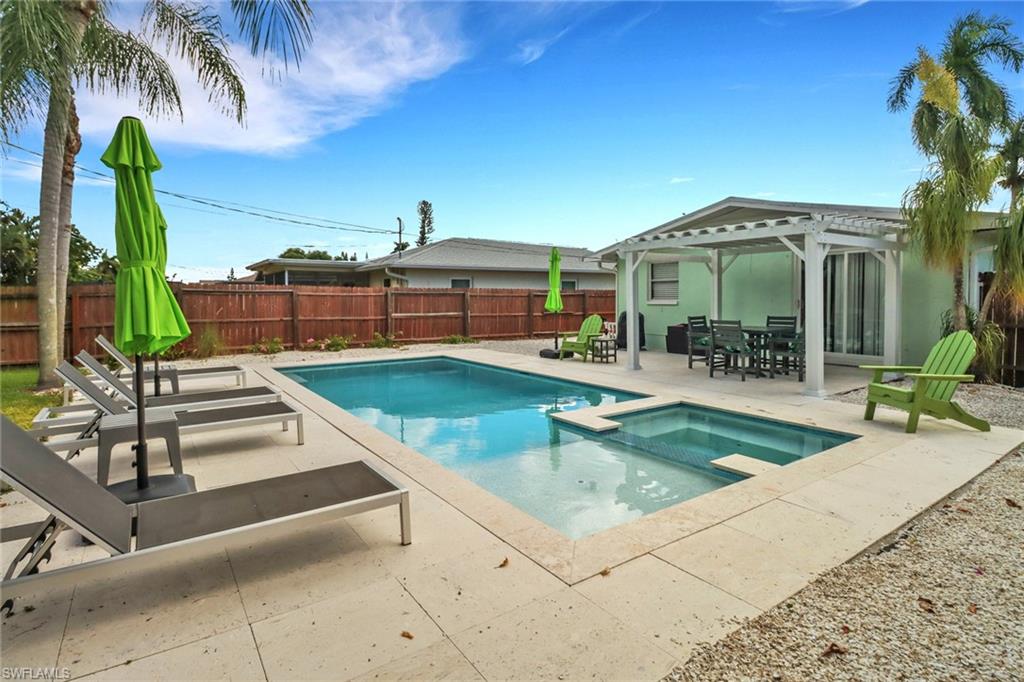 View of swimming pool with a patio, a pergola, and an in ground hot tub