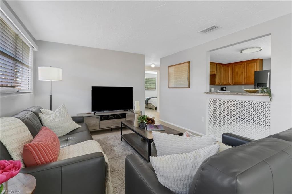 Living room with light hardwood / wood-style flooring and a healthy amount of sunlight