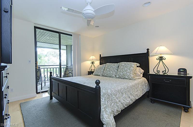 Bedroom featuring access to exterior, light wood finished floors, and a ceiling fan