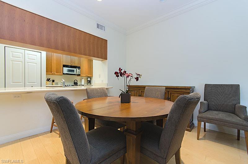 Dining room with light wood finished floors and ornamental molding